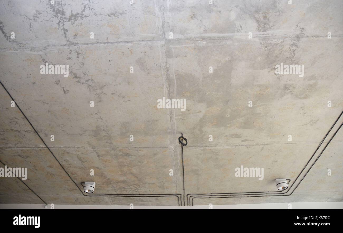 A modern interior with a loftstyle ceiling and lighting. Concrete