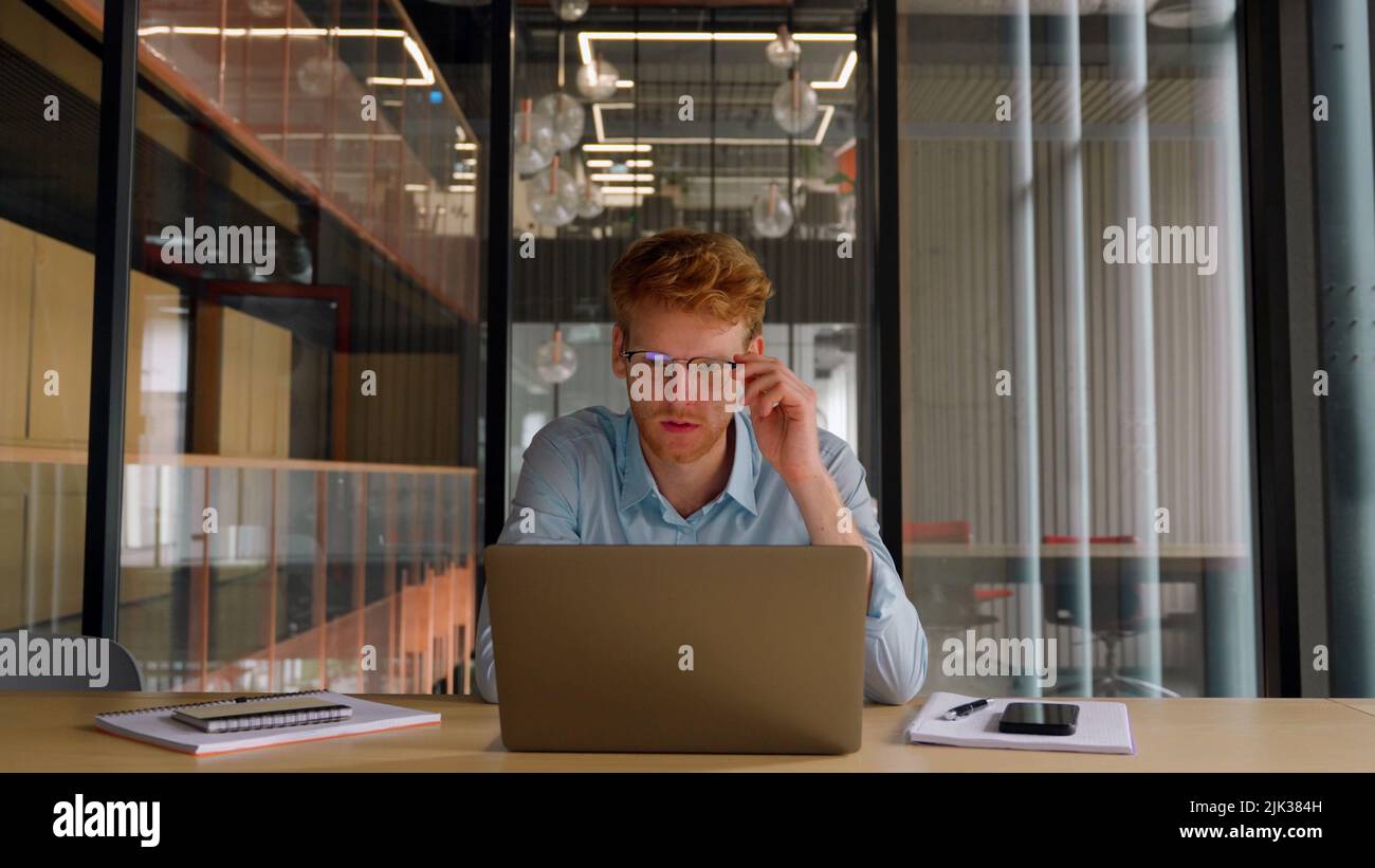 Young worried businessman checks financial crisis report on laptop computer.  Stock Photo