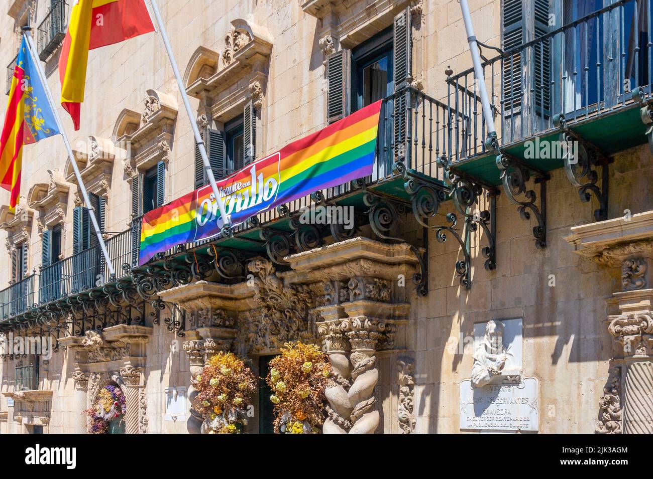 Alicante, Spain - July 10, 2022: Rainbow flag in the facade of the colonial building which is the City Hall Stock Photo