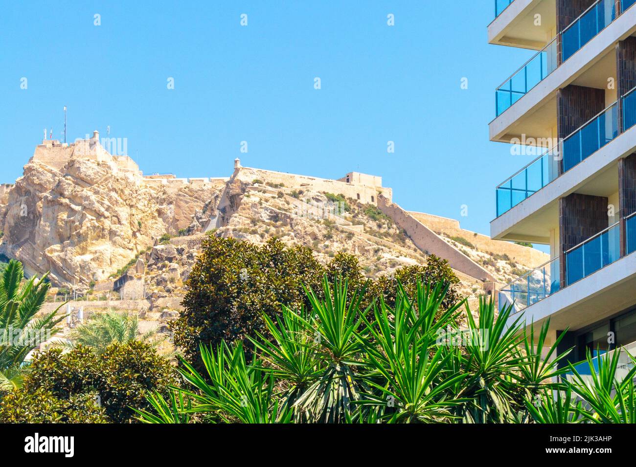 Alicante, Spain - July 10, 2022: Architecture contrast between the Santa Barbara Castle and a modern building Stock Photo