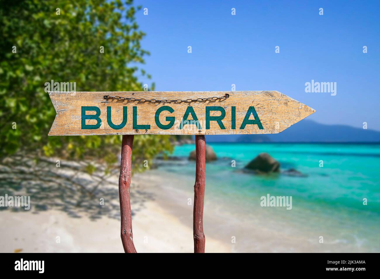 Bulgaria wooden arrow road sign against beach with white sand and turquoise water background. Travel to Bulgaria concept. Stock Photo