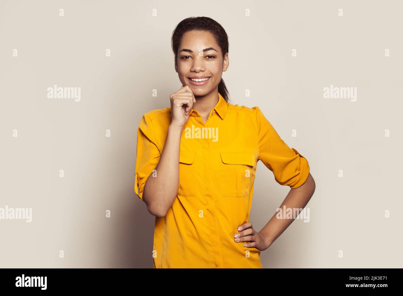 Young african american woman in casual yellow shirt laughing on white ...