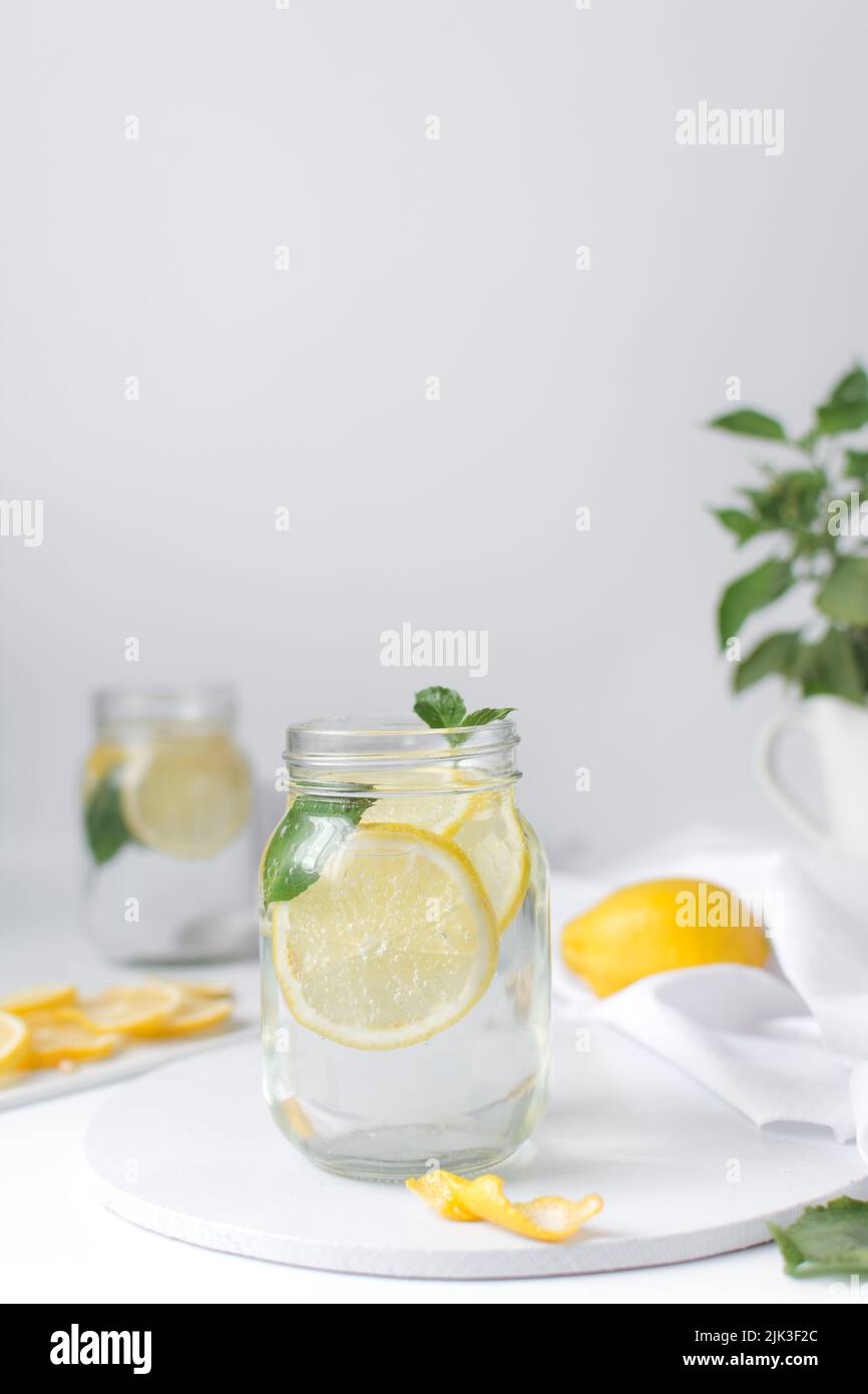 Lemon lime soda in a mason jar with a lemon slice and basil leaves, lemonade in a glass jar Stock Photo