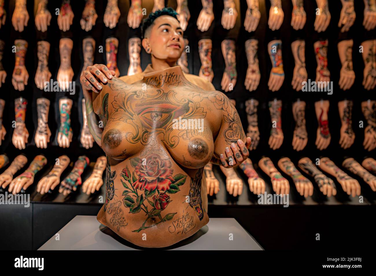 NOTE NUDITY Tattoo artist Charissa Gregson, AKA Rizza Boo, beside her artwork titled Starry Crown, a tattooed lifesize sillicone 3D scan of a real person, which has taken hundreds of hours to complete. Her artwork is part of a new exhibition addition to 'Tattoo: British Tattoo Art Revealed', at the National Maritime Museum, Falmouth, and Charissa is one of 14 black and people of colour tattoo artists, working in the UK, to contribute their contemporary designs, celebrating artwork on black and brown skin. Picture date: Saturday July 30, 2022. Stock Photo