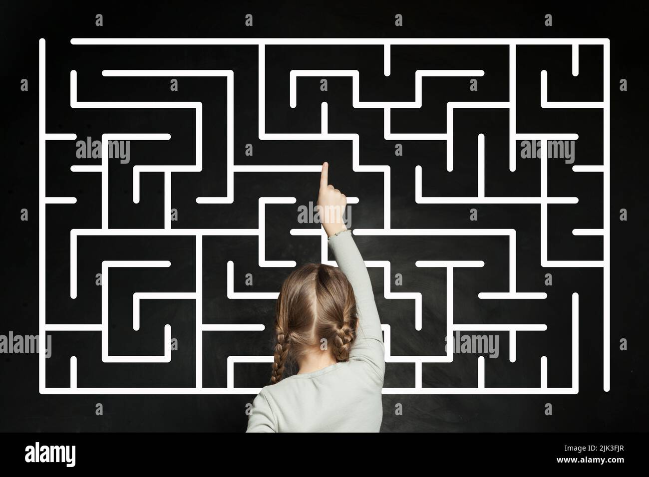 Child girl with labyrinth on blackboard background Stock Photo - Alamy