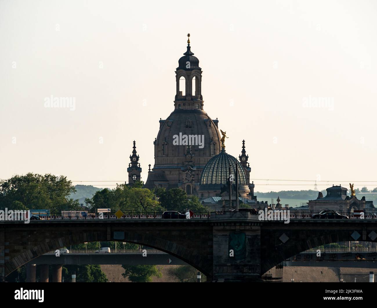 The famous Frauenkirche church building in the city skyline. The landmark of Dresden lit by evening sunlight. The travel destination is behind bridges Stock Photo
