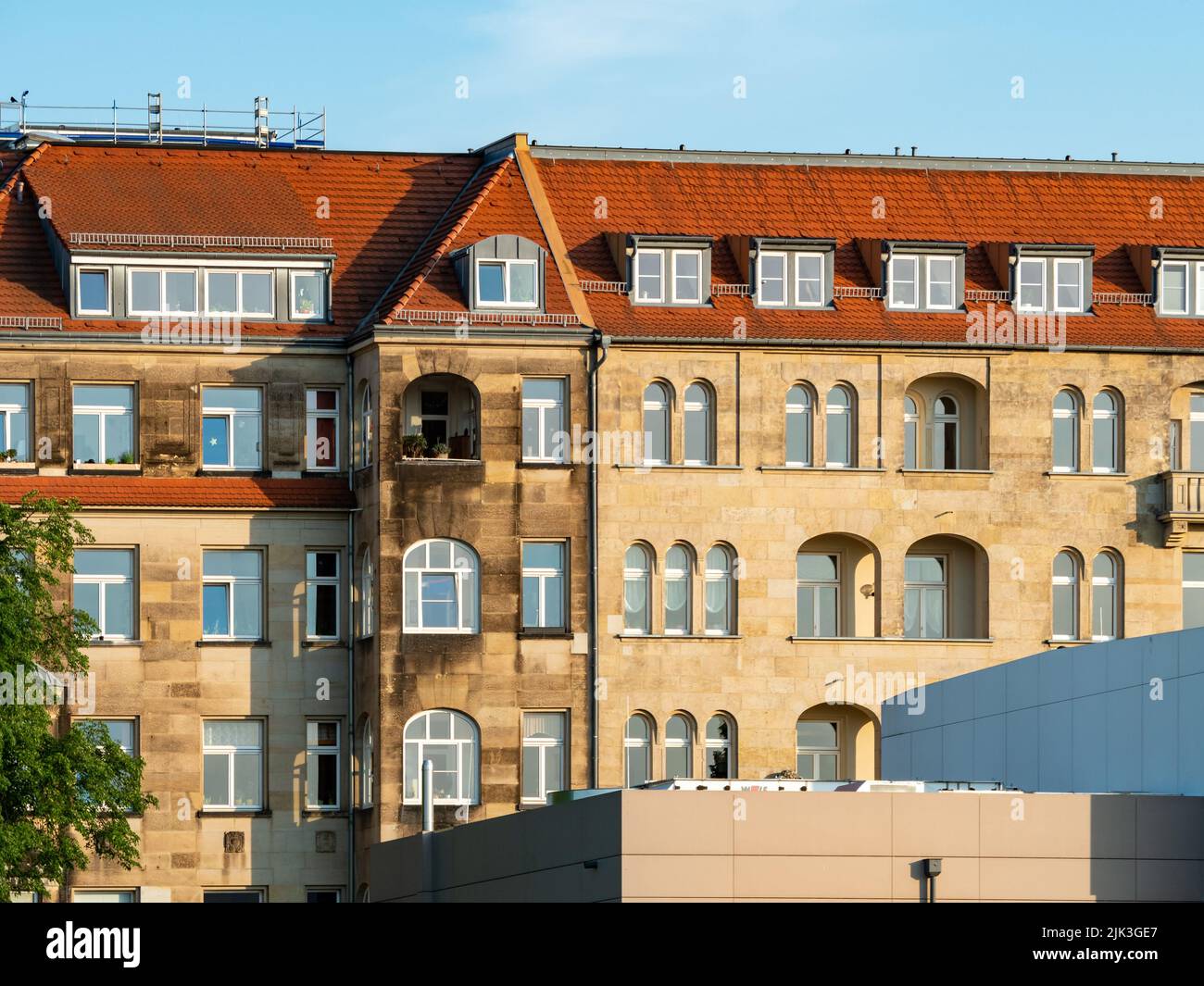 Big old house with a sandstone facade in the city. Red tiled rooftop in good condition. Architecture in Saxony. Residential building exterior. Stock Photo