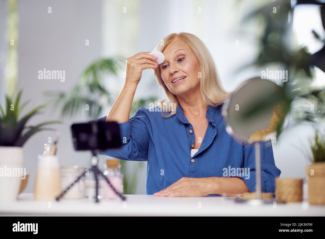 A senior woman blogging about how to properly remove make-up from face. Stock Photo