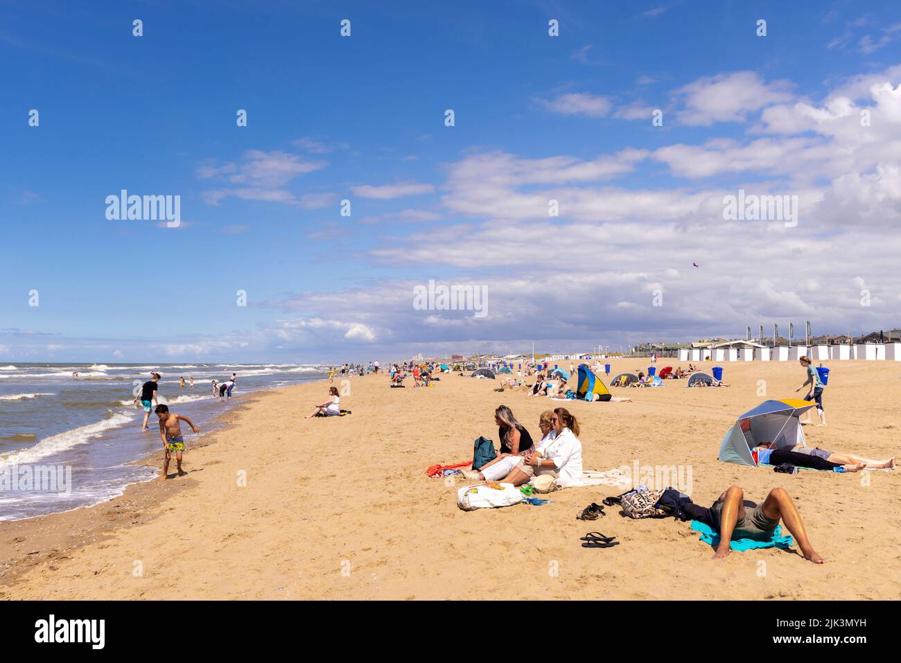 Summertime along the North Sea: People relaxing and sunbathing on the beach in Katwijk, South Holland, The Netherlands. Stock Photo