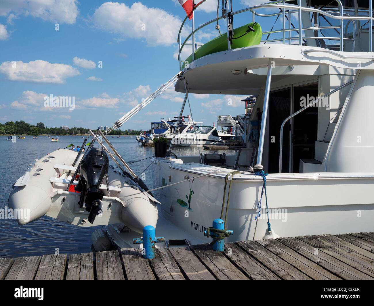 Rear end of a motor vessel with a kayak and a speedboat attached. Moored at Dow's Lake Pavilion, Ottawa, Ontario, Canada. Stock Photo