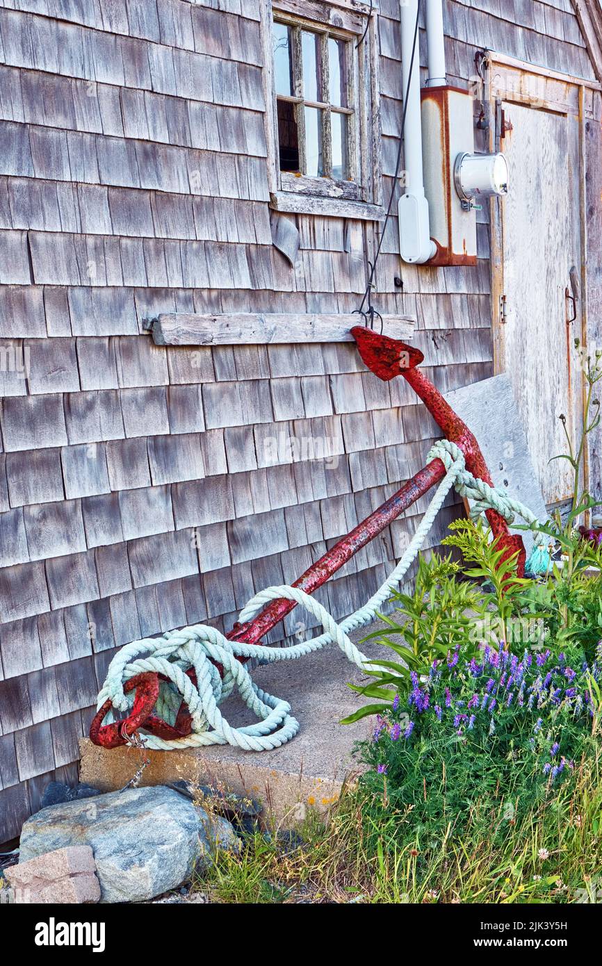 Old rusty anchor found leaning against a fish hut in the tiny fishing villahe of Peggy's Cove Nova Scotia. Stock Photo