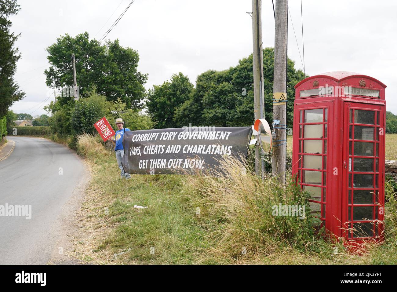 A protester near Daylesford House in Gloucestershire, where Prime Minister Boris Johnson and wife Carrie are holding a first wedding anniversary party for friends and family. Picture date: Saturday July 30, 2022. Stock Photo