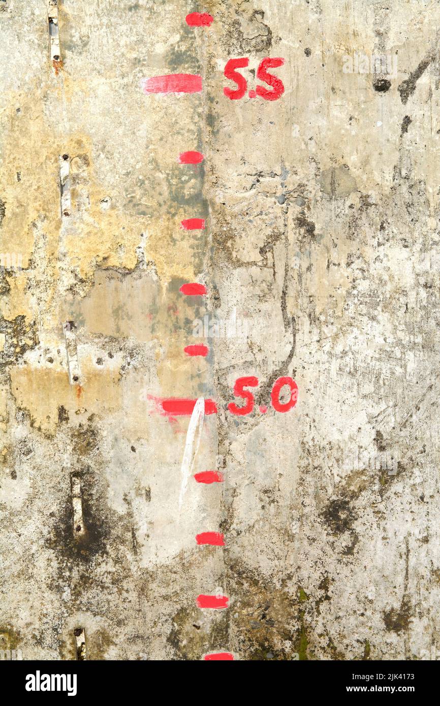 Detail of the tide gauge on the harbour wall of Appledore (North Devon, UK) showing red paint markings and numbers between 45 and 55. Stock Photo