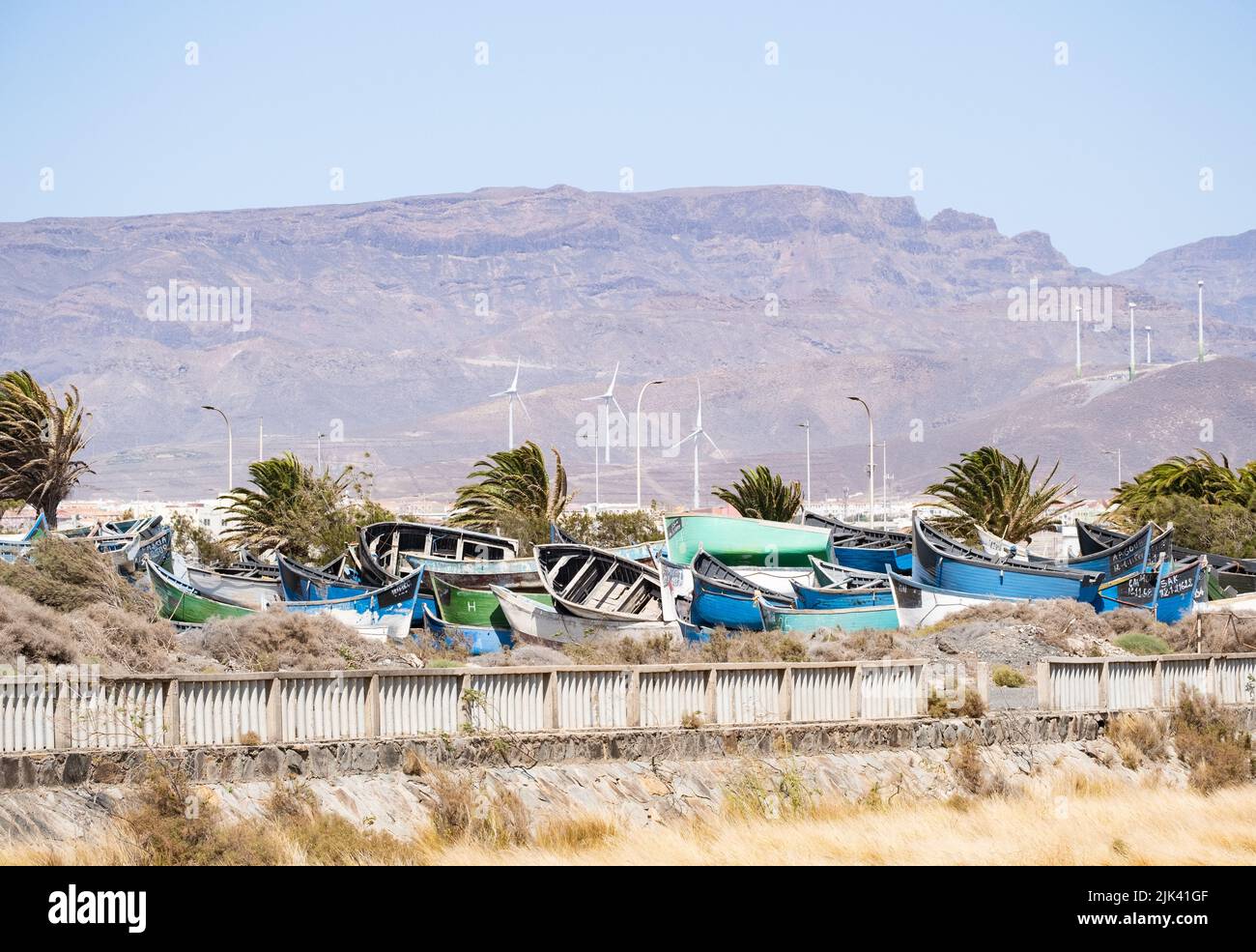 Gran Canaria, Canary Islands, Spain. 30th July, 2022.Locals complain as hundreds of fishing boats used by migrants to make the perilous crossing from Africa to Gran Canaria are moved from the port area to land near a residential buildings. Thousands, mainly young sub saharan men and some women and children, have made the crossing in these boats in 2022. Hundreds have died and many boats have gone missing en route. Credit: Alan Dawson/ Alamy Live News. Stock Photo