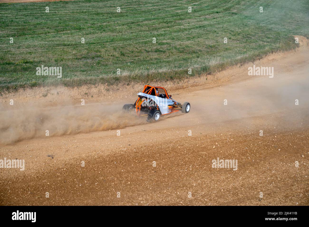 buggies on the autocross track, skidding, dust and dirt flying under