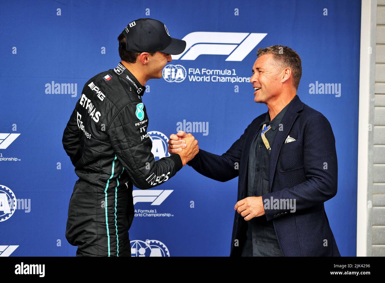 Mogyorod, Hungary. 30th July, 2022. (L to R): George Russell (GBR) Mercedes AMG F1 celebrates his pole position in qualifying parc ferme with Tom Kristensen (DEN). Hungarian Grand Prix, Saturday 30th July 2022. Budapest, Hungary. Credit: James Moy/Alamy Live News Stock Photo