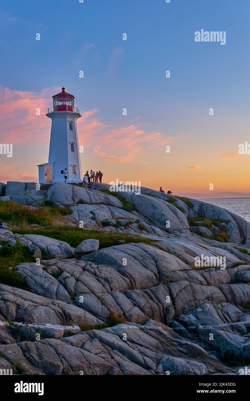 Tourists converge on the iconic Peggy's Cove lighthouse tp view the amazing sunset. Stock Photo