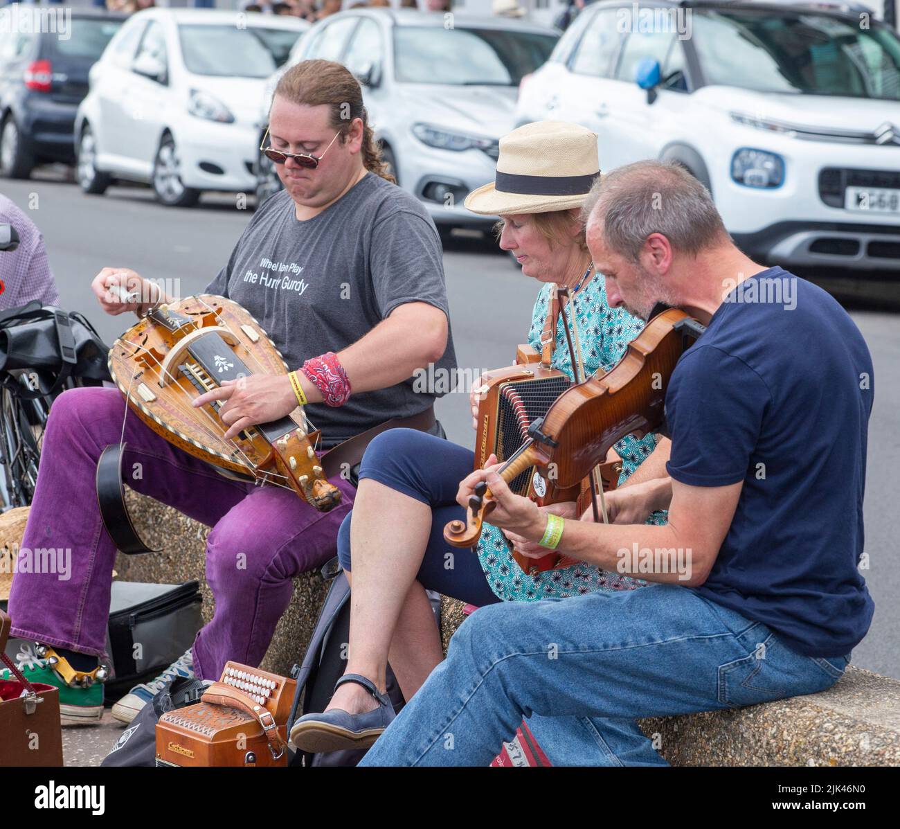 Sidmouth, 30th July 2022 Wheel Men in action, a hurdy gurdy man with band on the Esplanade at Sidmouth as the annual Folk Week Festival gets underway. Tony Charnock/Alamy Live News Stock Photo