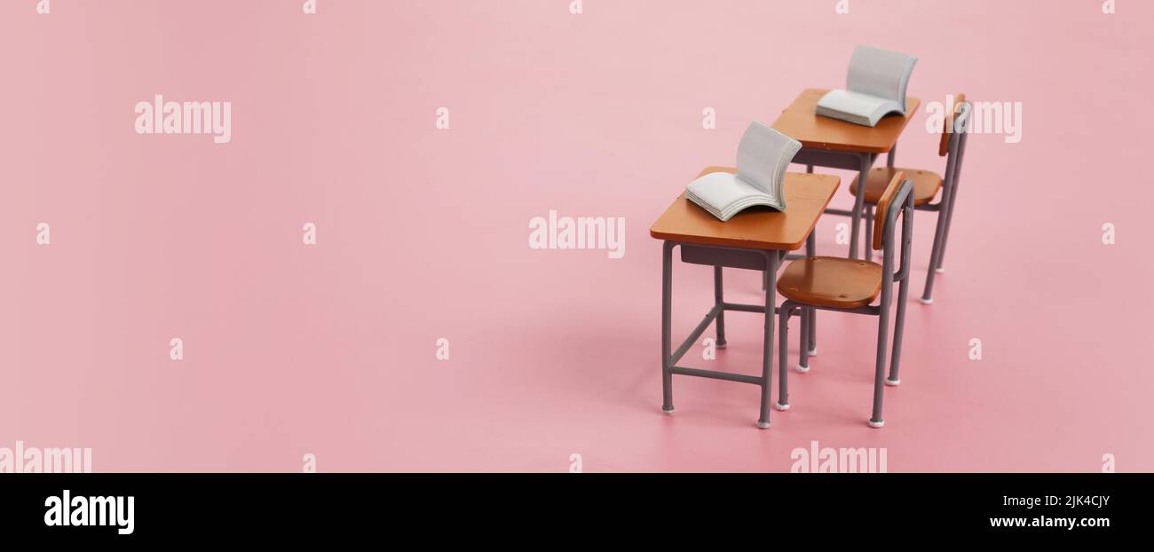 School desk with books on pink background Stock Photo
