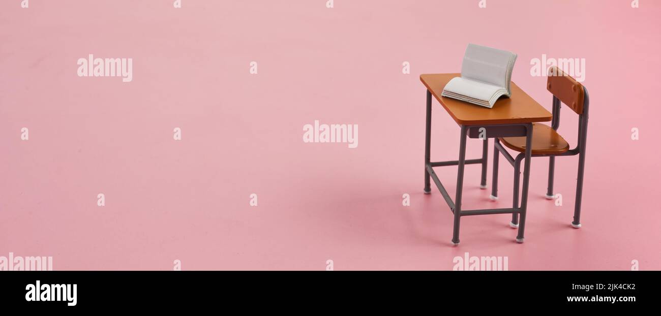 School desk with books on pink background Stock Photo