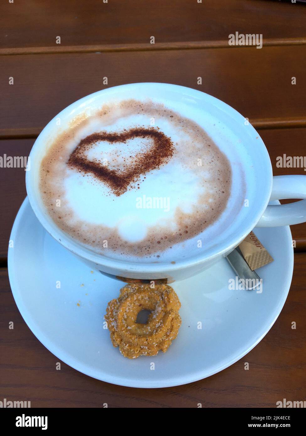 Tasse Cappuccino mit einem Herz aus Kakao verziertem Milchschaum Stock Photo