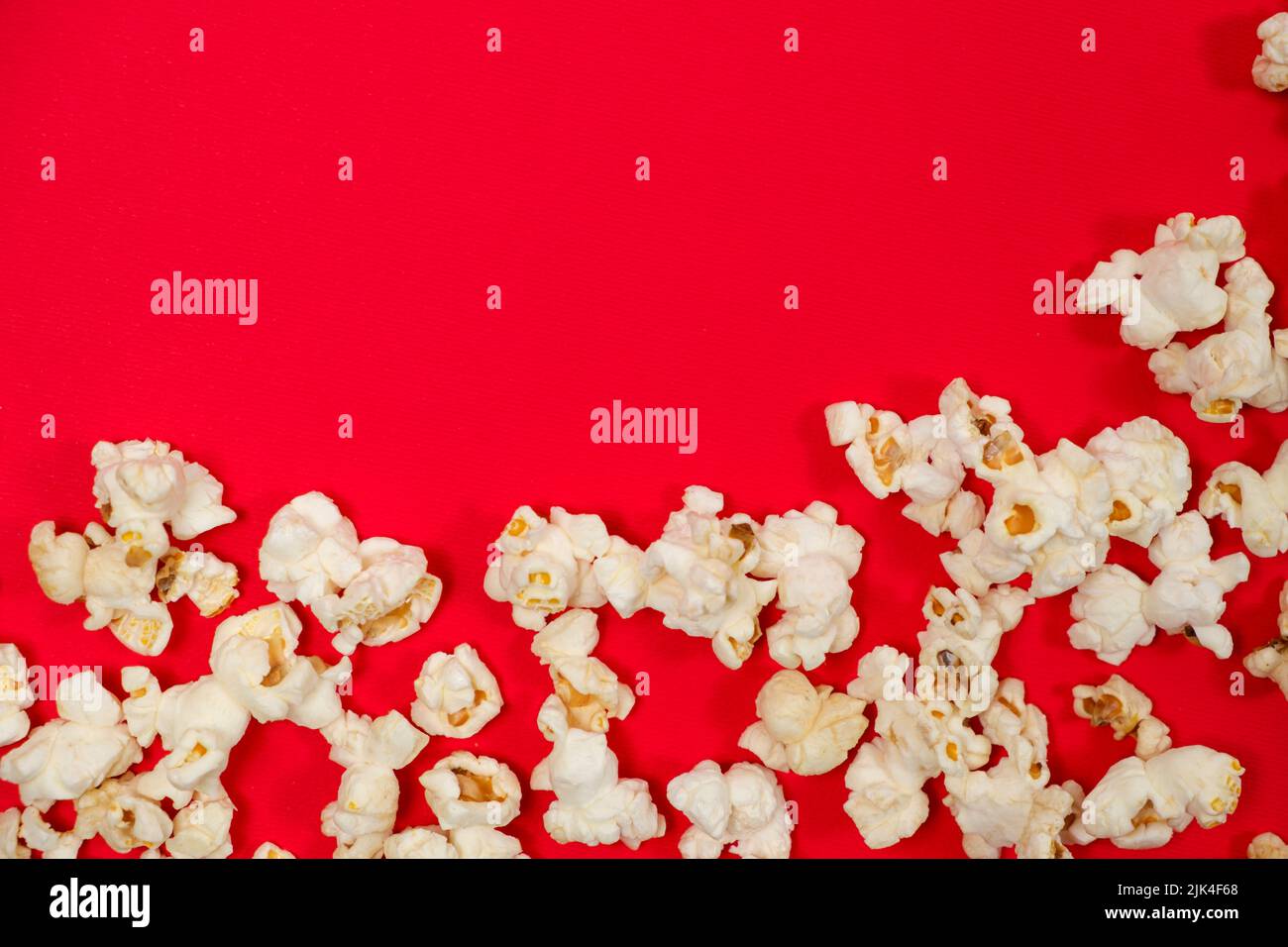 Popcorn on red background, top view with space for text Stock Photo