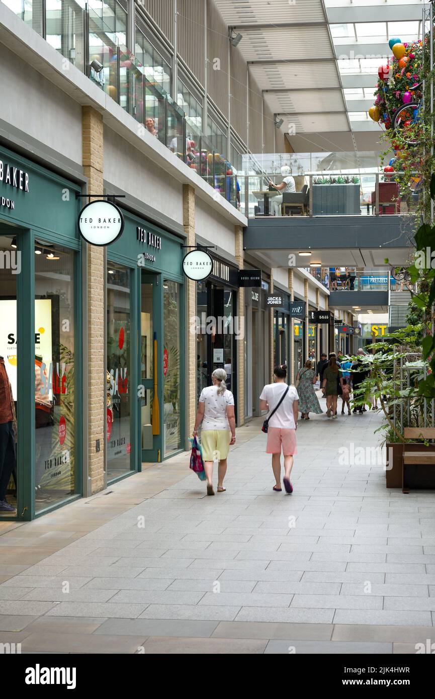 Interior of Westgate Shopping Centre with people walking past retail shops, Oxford, UK Stock Photo