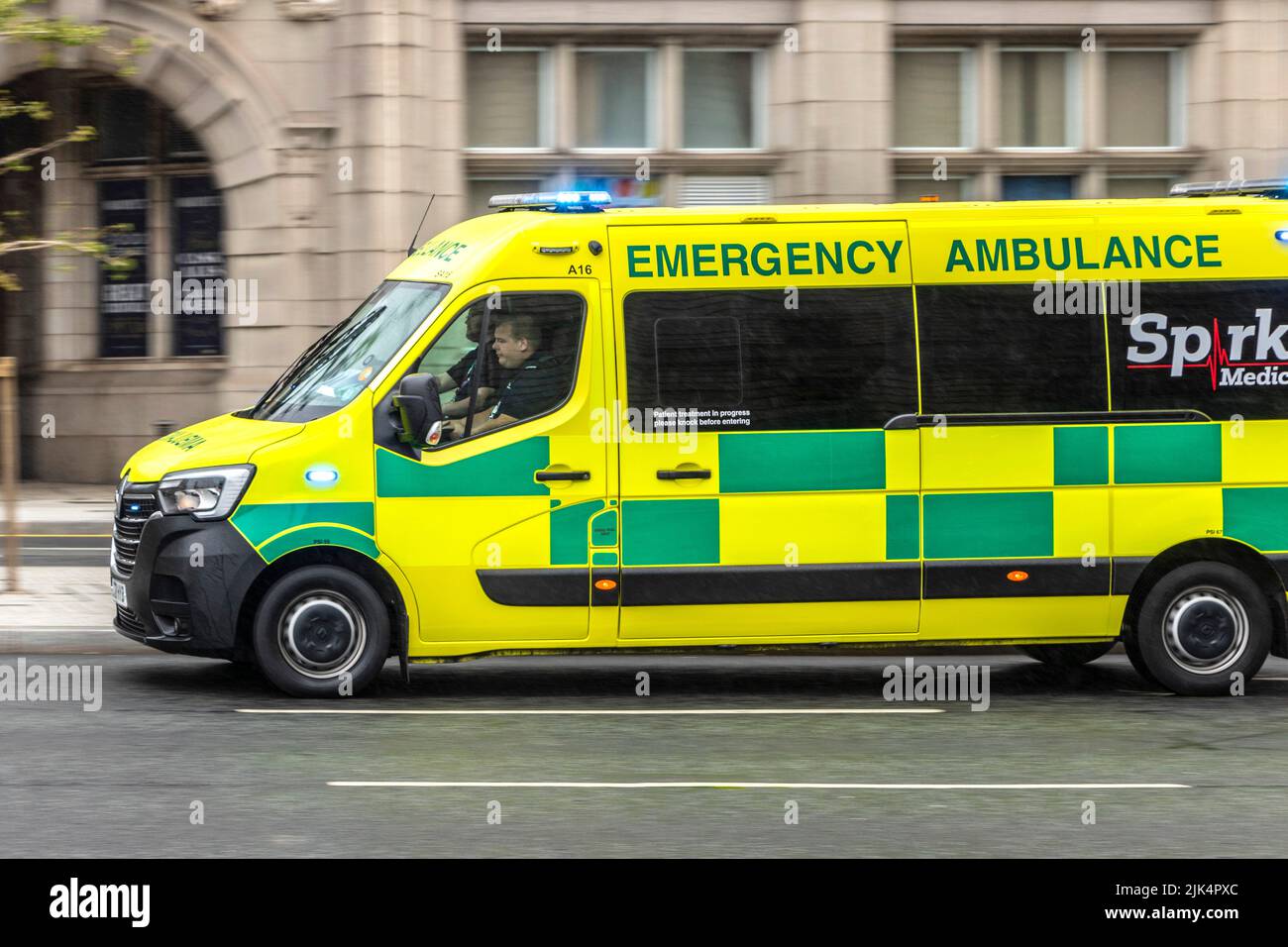 spark medical group emergency ambulance panning shot at speed with blues and twos Stock Photo