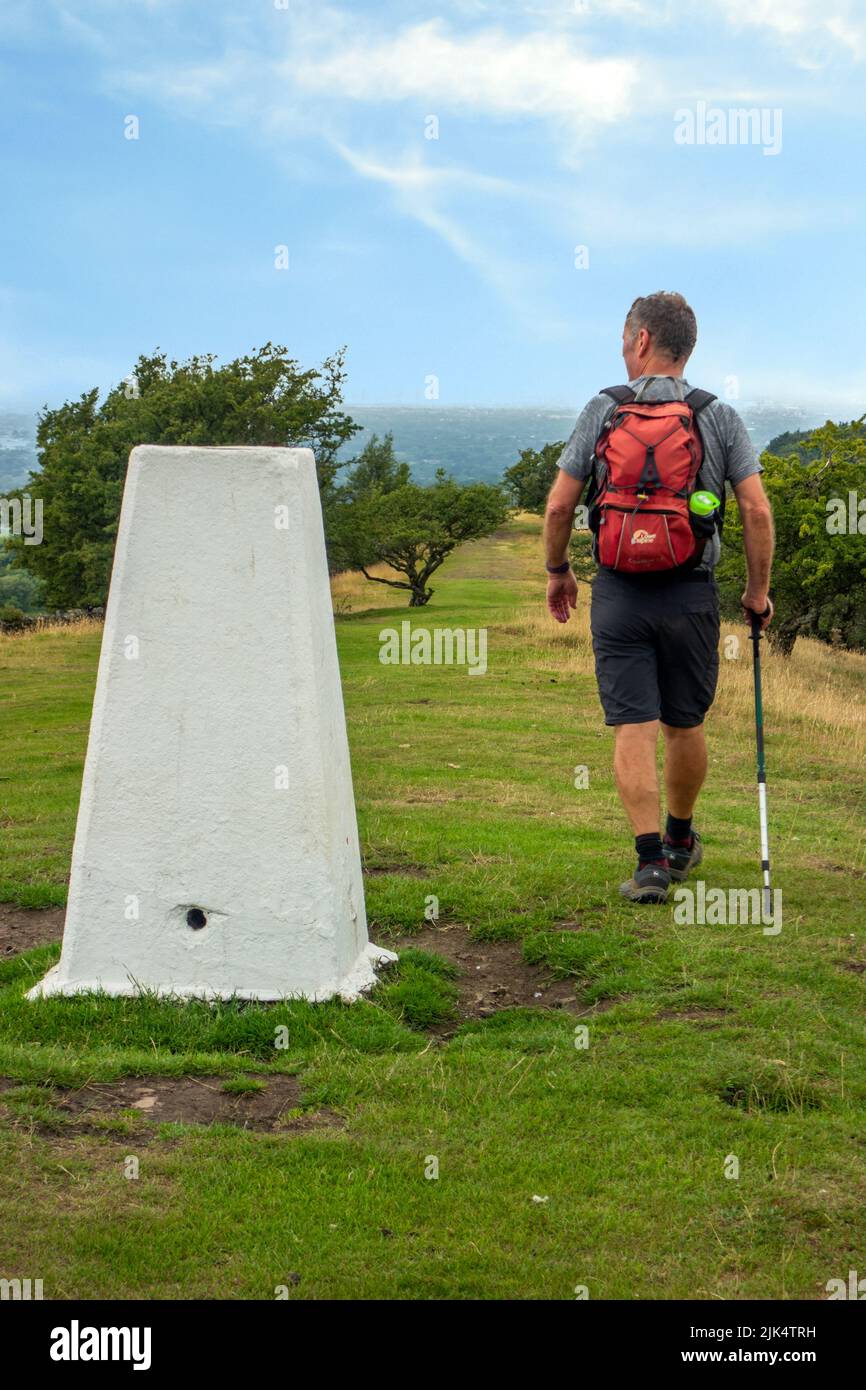Man walking past the trig point on the Gritstone trail on the ridge of ...