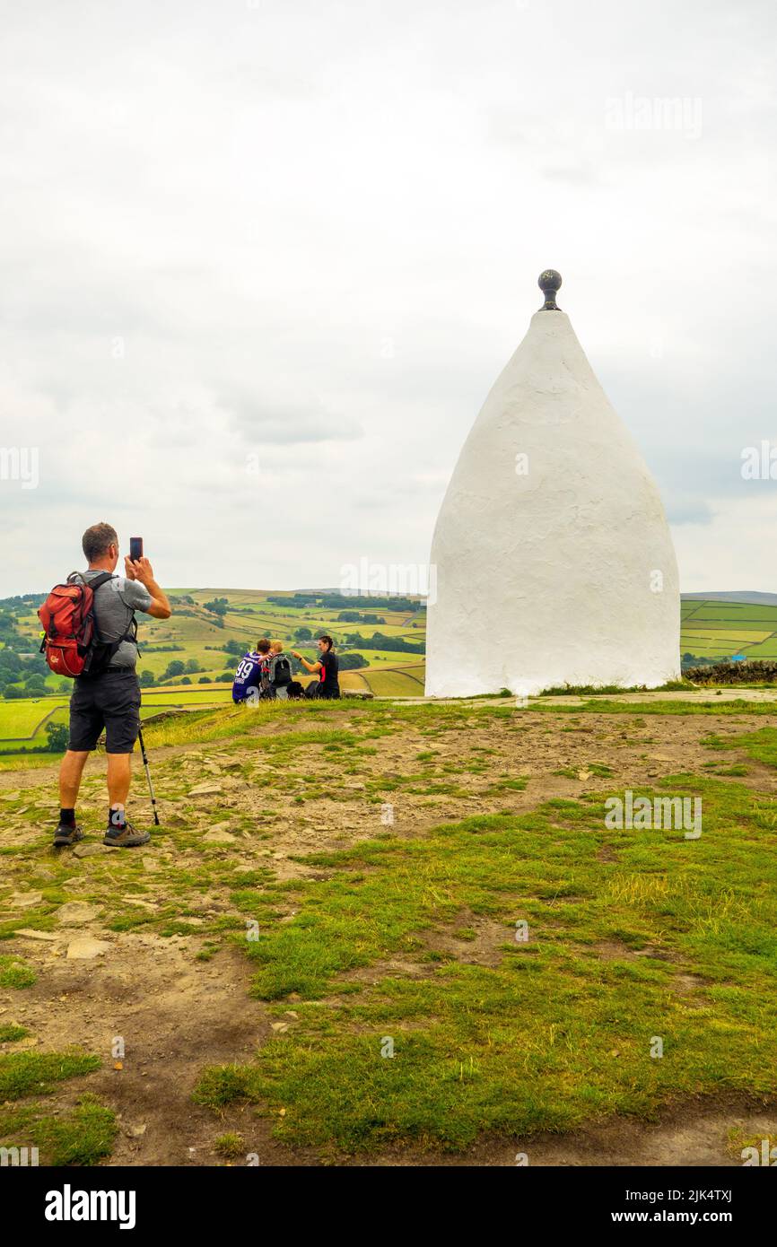 Man walking past the Cheshire landmark of White Nancy a structure on the Gritstone trail at  the top of Kerridge Hill, Bollington Stock Photo