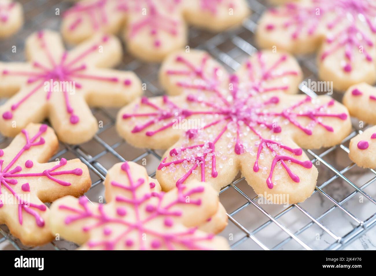 Decorating Christmas sugar cookies with royal icing and sprinkles Stock