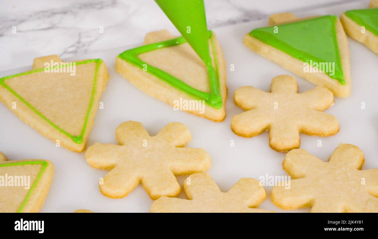 Stp by step. Icing Christmas treeshaped sugar cookies with green royal
