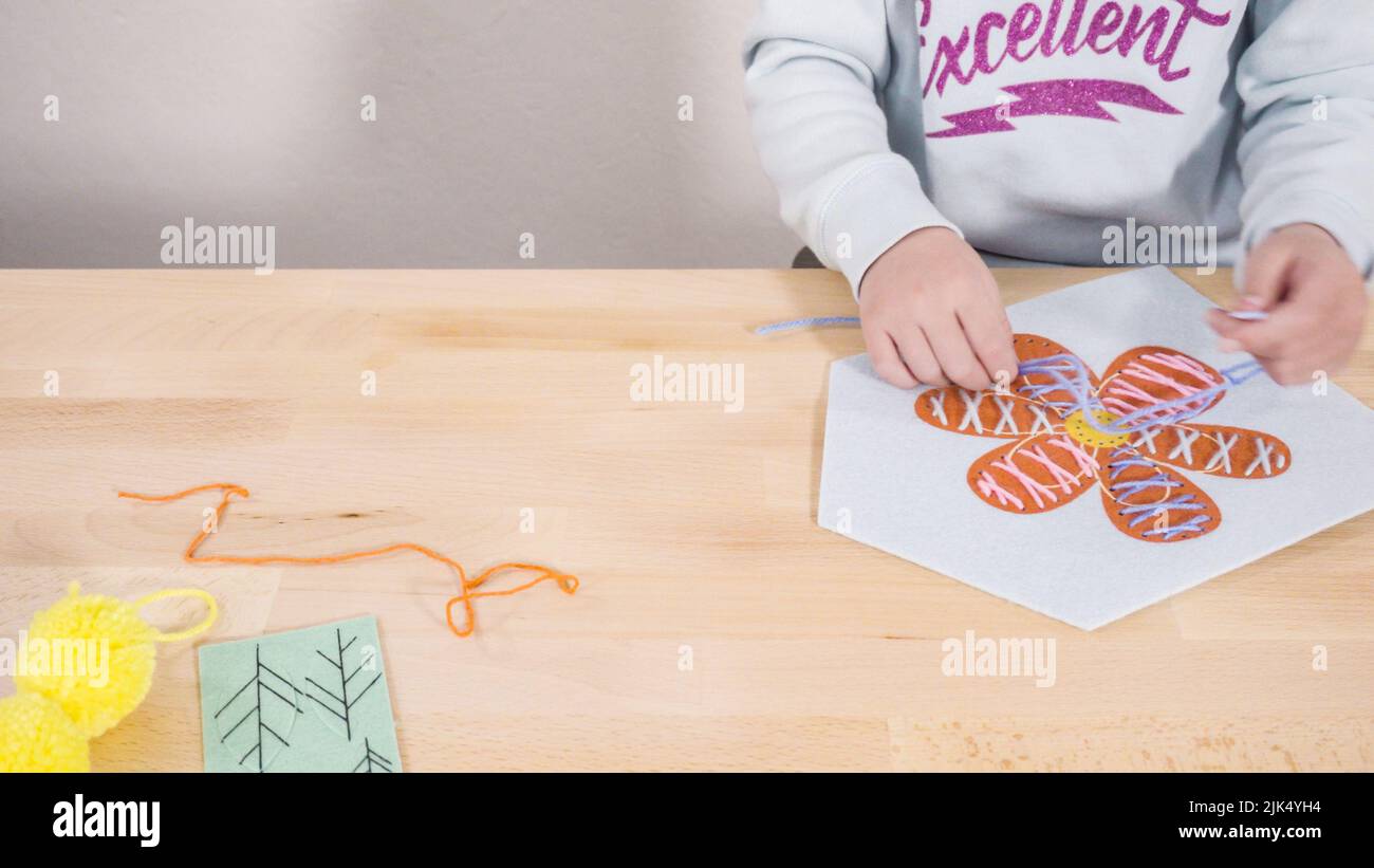 Little girl learning how to sew with sewing craft kit for kids Stock