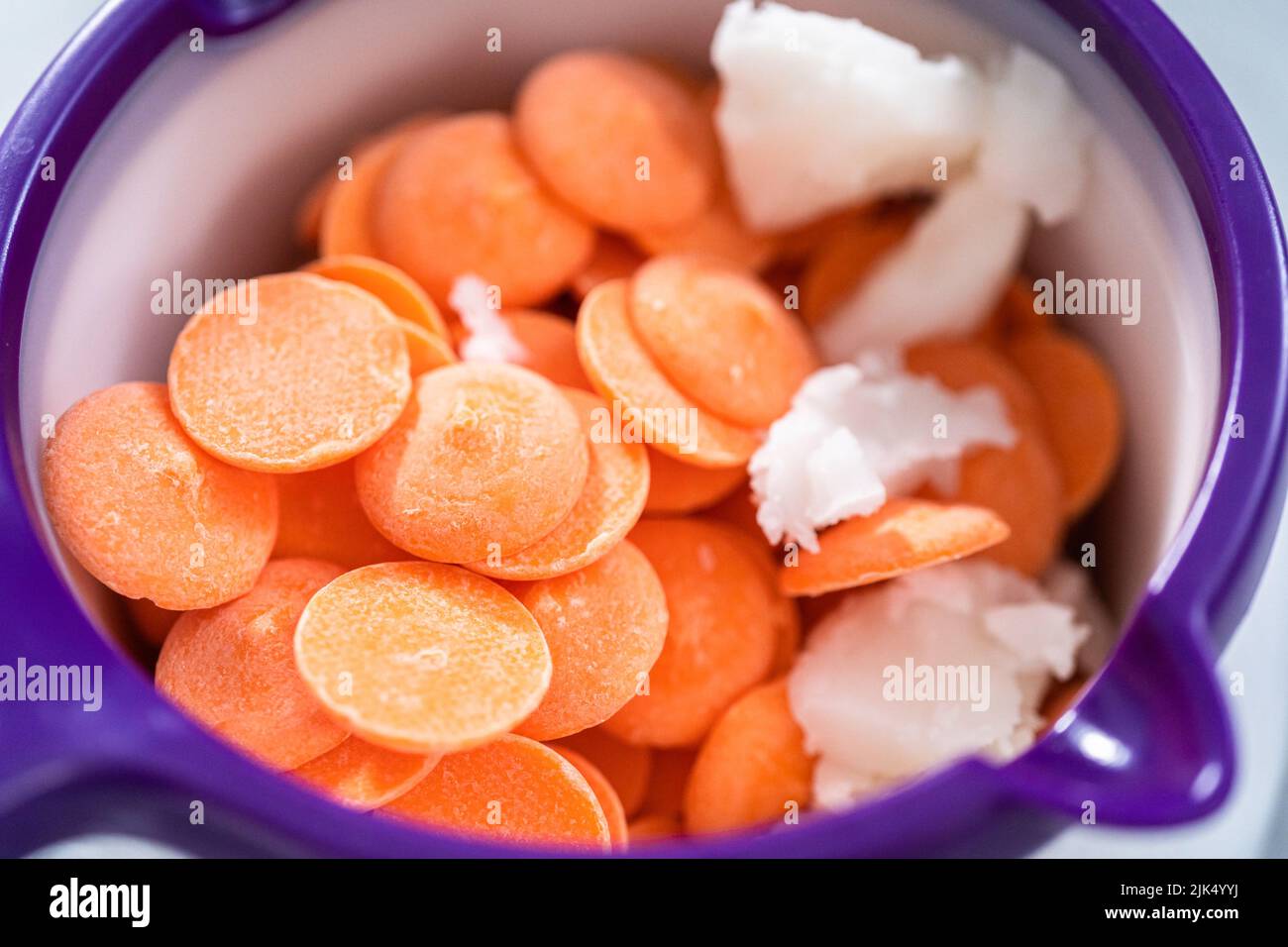 Melting color chocolate chips in a candy melting pot to make carrot
