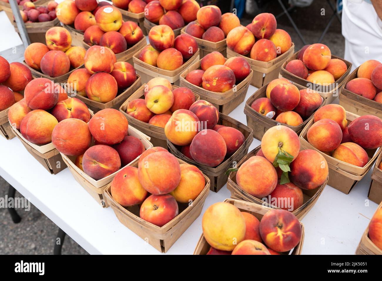 Fresh yellow peaches in cardboard crates at Farmers Market Stock Photo