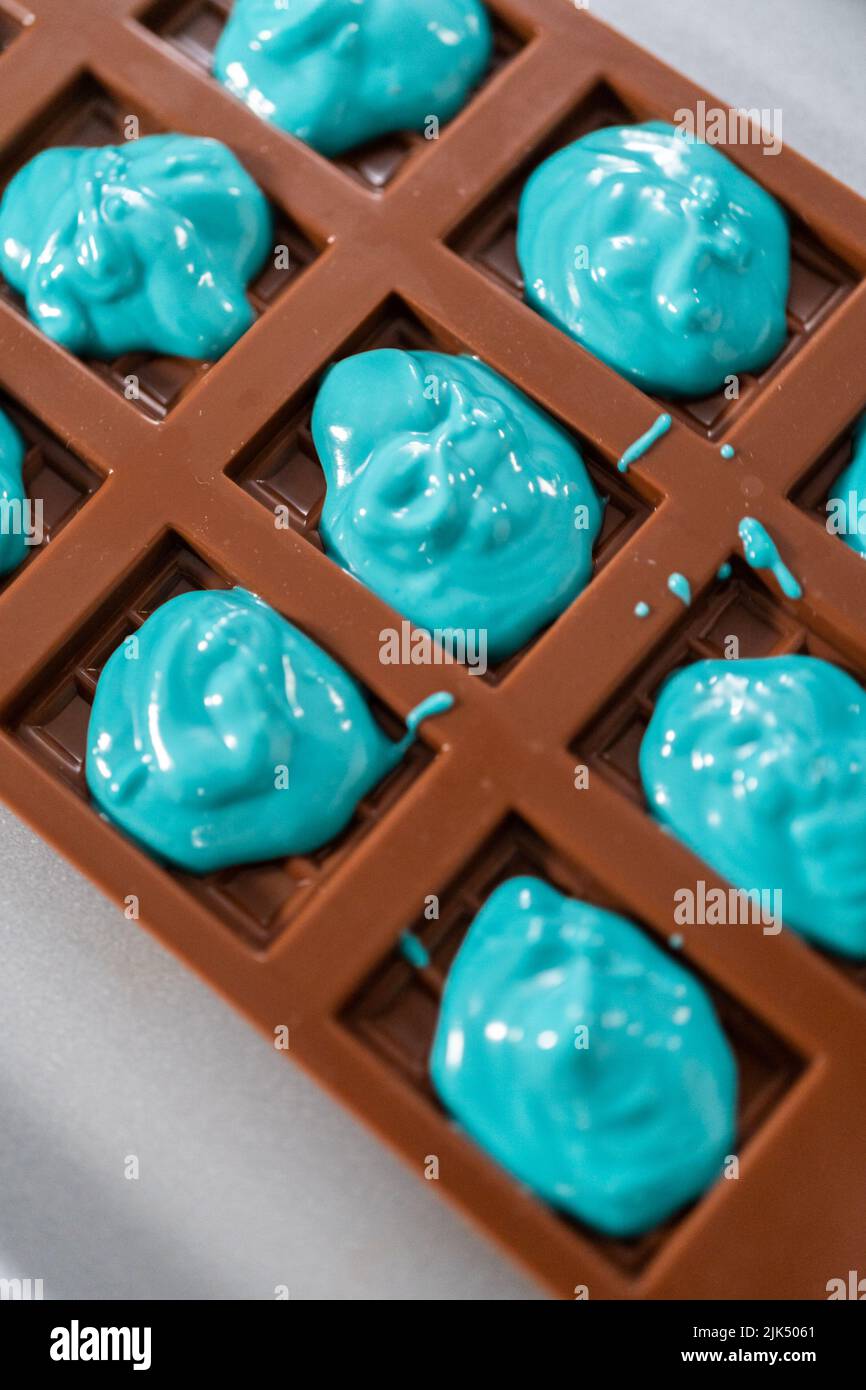 Premium Photo  Filling in chocolate silicone molds with melted chocolate  to preparing mini mermaid chocolate bars.