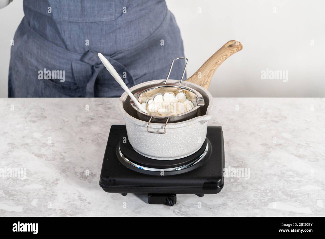 Melting white chocolate chips in a stainless steel double boiler pot