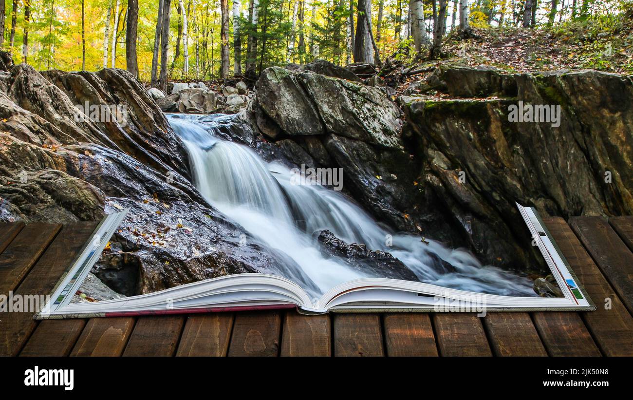Open book on wooden deck with waterfall in autumn season Stock Photo