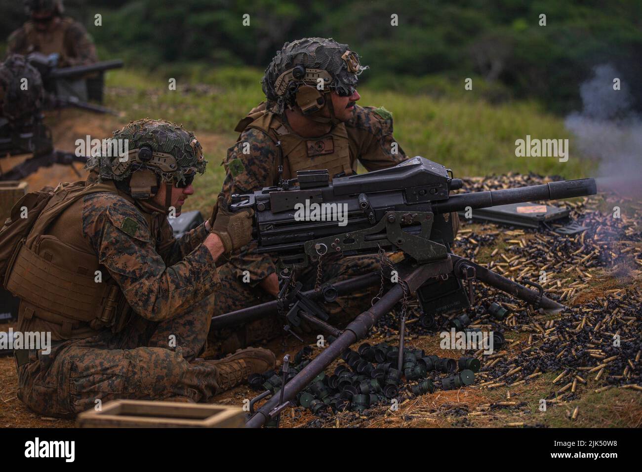 U.S. Marine Corps Lance Cpl. Charles Joch (left) and Lance Cpl. Maxwell Cole (right), both machine gunners with 3d Battalion, 2d Marines, fire an MK19 grenade launcher during a Tactical Small Unit Leader Course on Camp Schwab, Okinawa, Japan, July 28, 2022. This training improved the Marines’ proficiency at the tactical level and developed small-unit leadership. 3/2 is forward deployed in the Indo-Pacific under 4th Marines, 3d Marine Division as part of the Unit Deployment Program. Joch is a native of Centreville, Virginia and Cole is a native of Hartsville, South Carolina. (U.S. Marine Corps Stock Photo