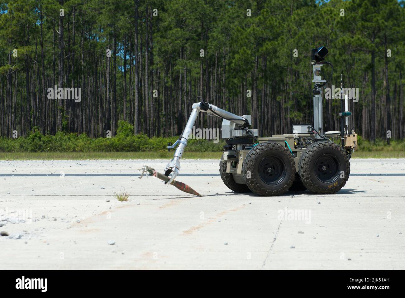 An immediate visualization and neutralization, or IVAN, small robot performs unexploded ordnance mitigation during a qualification, testing and evaluation for the Air Force rapid airfield damage assessment system at Silver Flag Training Site, Tyndall Air Force Base, Florida, May 14, 2015. Representatives from several organizations came together with the Air Force Civil Engineer Center’s detachment to participate in the QT&E to assess how well the RADAS operated on its own and how well it integrated with airfield recovery processes. (U.S. Air Force photo by Jessica Echerri) Stock Photo