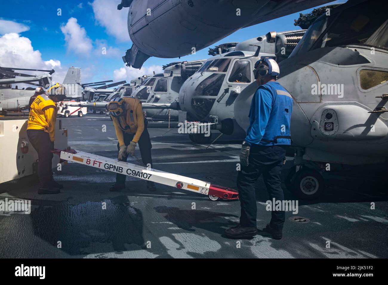 220728-N-VJ326-2216 PACIFIC OCEAN (July 28, 2022) – Sailors attach a spotting dolly to an MV-22 Osprey tiltrotor aircraft assigned to Marine Medium Tiltrotor Squadron (VMM) 262 (Reinforced) on the flight deck aboard amphibious assault carrier USS Tripoli (LHA 7), July 28, 2022. Tripoli is operating in the U.S. 7th Fleet area of operations to enhance interoperability with allies and partners and serve as a ready response force to defend peace and maintain stability in the Indo-Pacific region. (U.S. Navy photo by Mass Communication Specialist 2nd Class Malcolm Kelley) Stock Photo