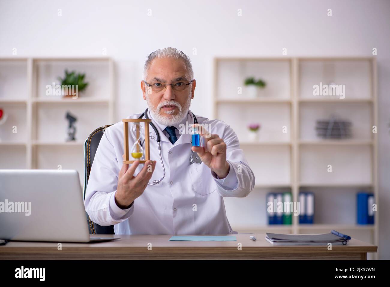 Old doctor in time management concept Stock Photo