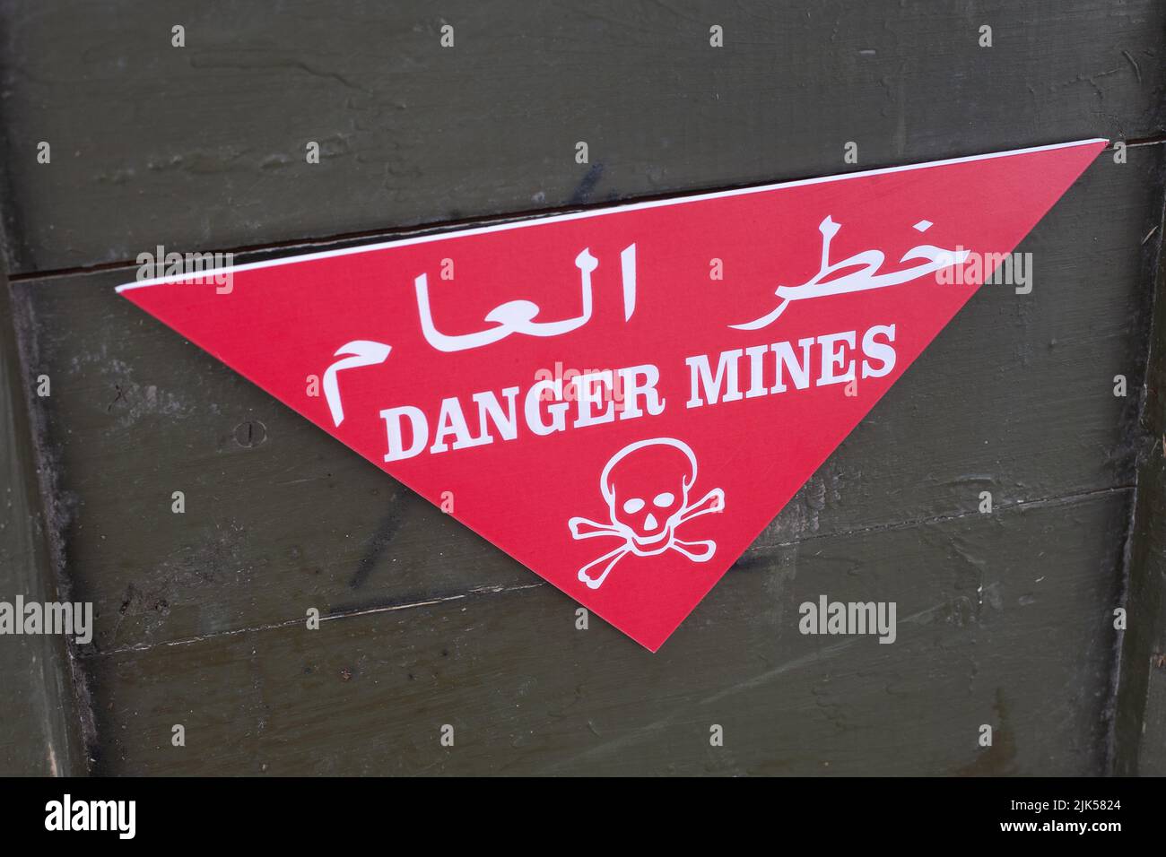 Arabic/English minefield warning red sign Danger Mines. White skull