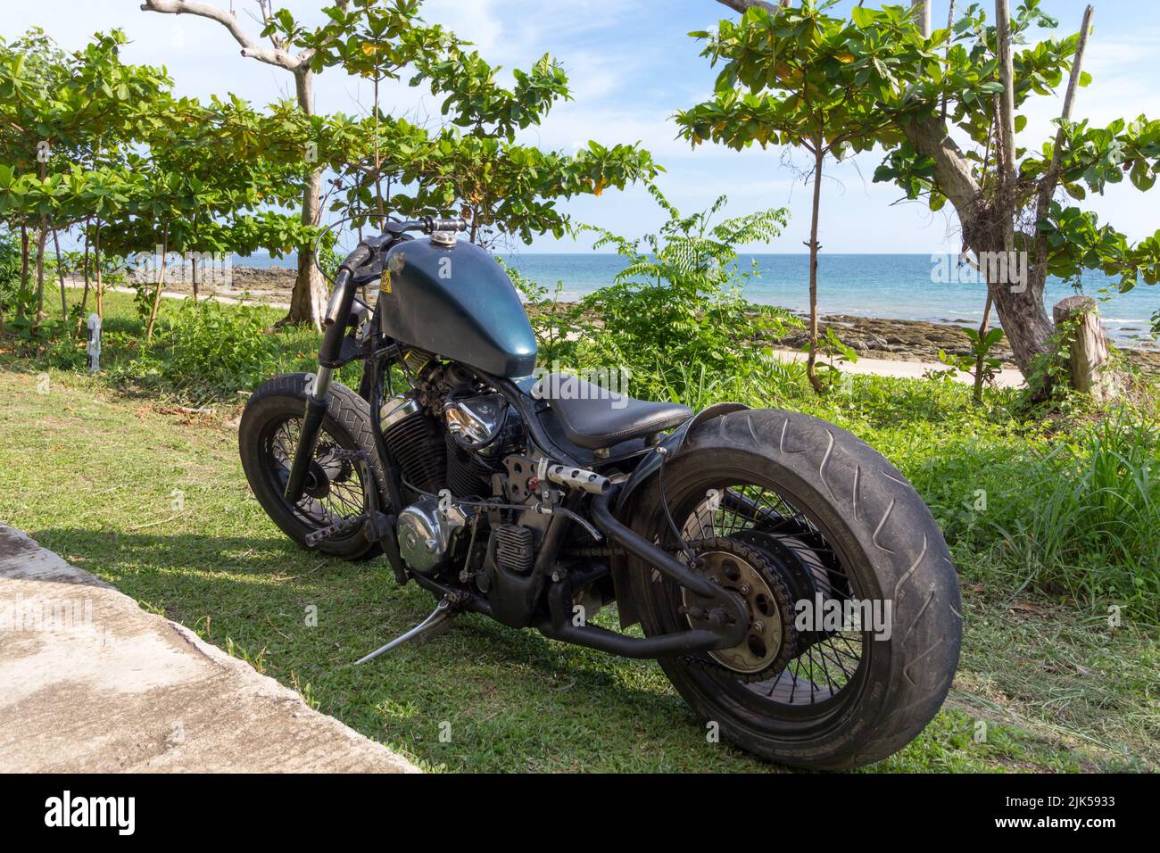 https://c8.alamy.com/comp/2JK5933/a-custom-chopper-motorbike-parked-on-grass-next-to-a-tropical-beach-rat-bike-low-rider-honda-engine-2JK5933.jpg