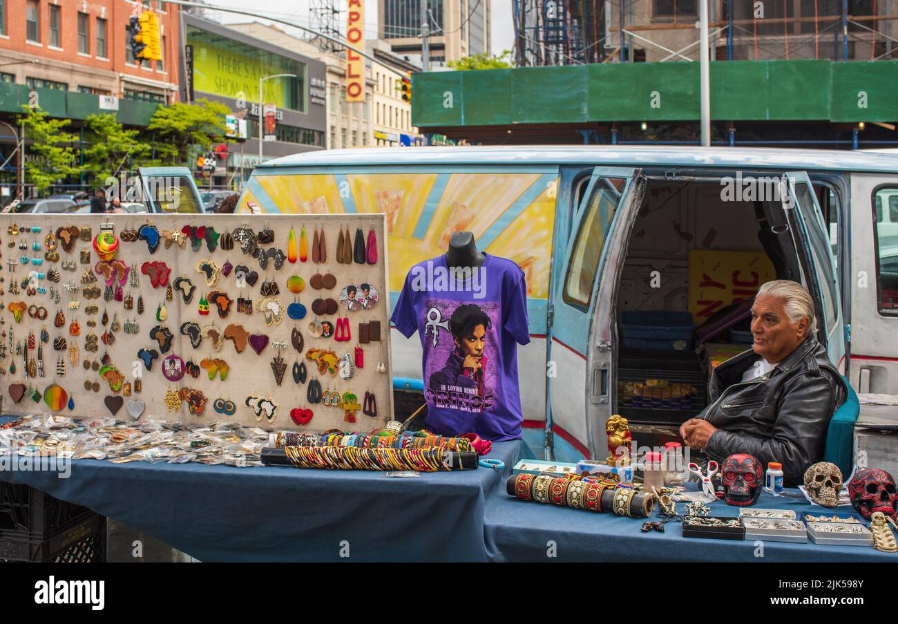 Man sells jewelry and souvenirs at tables on Manhattan sidewalk. Stock Photo