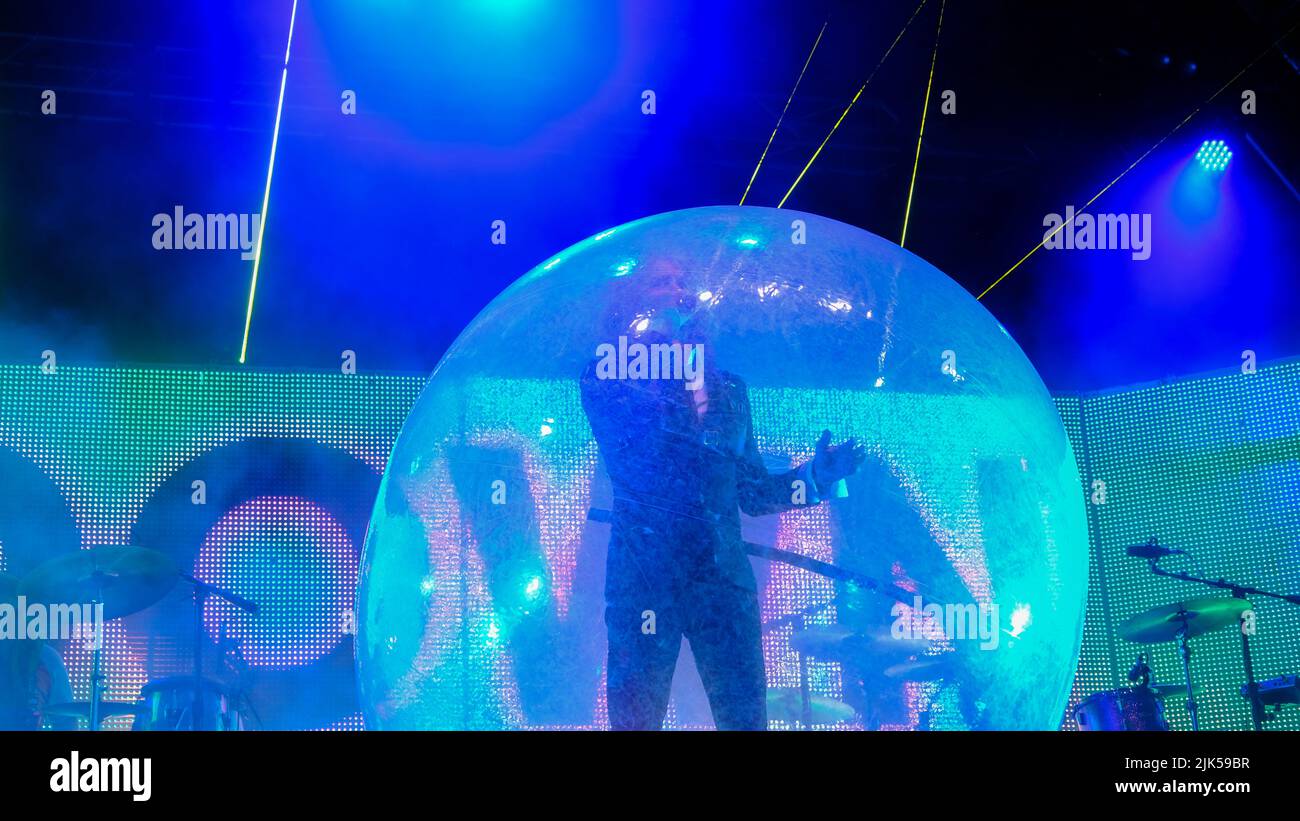 Malmesbury, Wiltshire, UK. 30th July, 2022. Malmesbury Wiltshire. Womad Festival. American Psychedelic band The Flaming Lips featuring Wayne Coyne performing in a Plastic Bubble and with a blowup robot, all headling on the Open Air Stage. Credit: charlie bryan/Alamy Live News Stock Photo