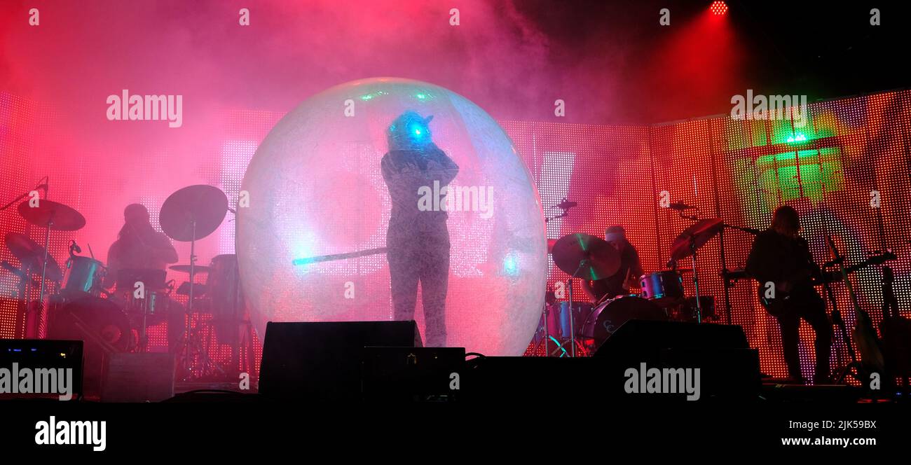 Malmesbury, Wiltshire, UK. 30th July, 2022. Malmesbury Wiltshire. Womad Festival. American Psychedelic band The Flaming Lips featuring Wayne Coyne performing in a Plastic Bubble and with a blowup robot, all headling on the Open Air Stage. Credit: charlie bryan/Alamy Live News Stock Photo