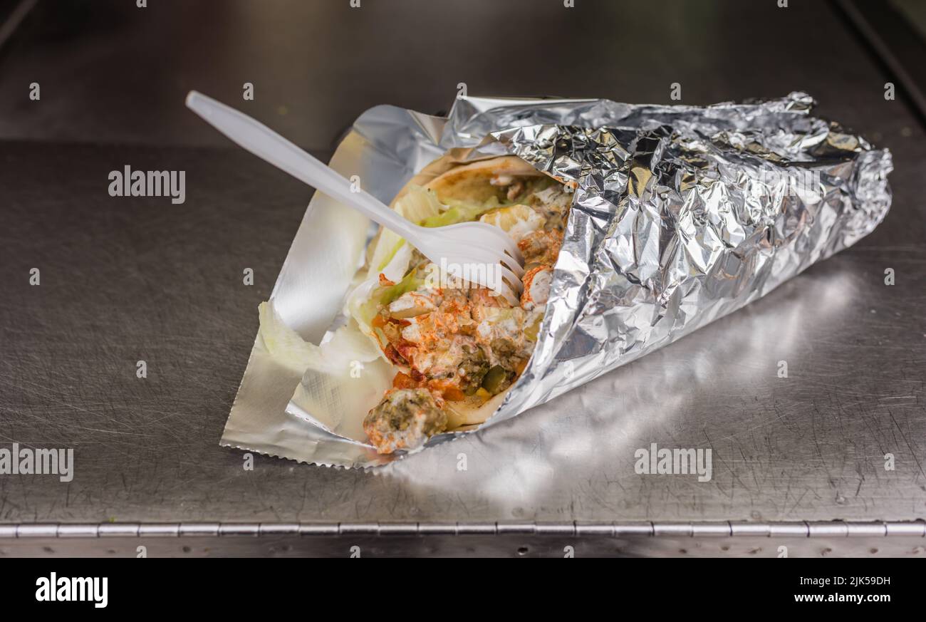 Gyro wrapped up to eat on the run in Manhattan with fork. Stock Photo