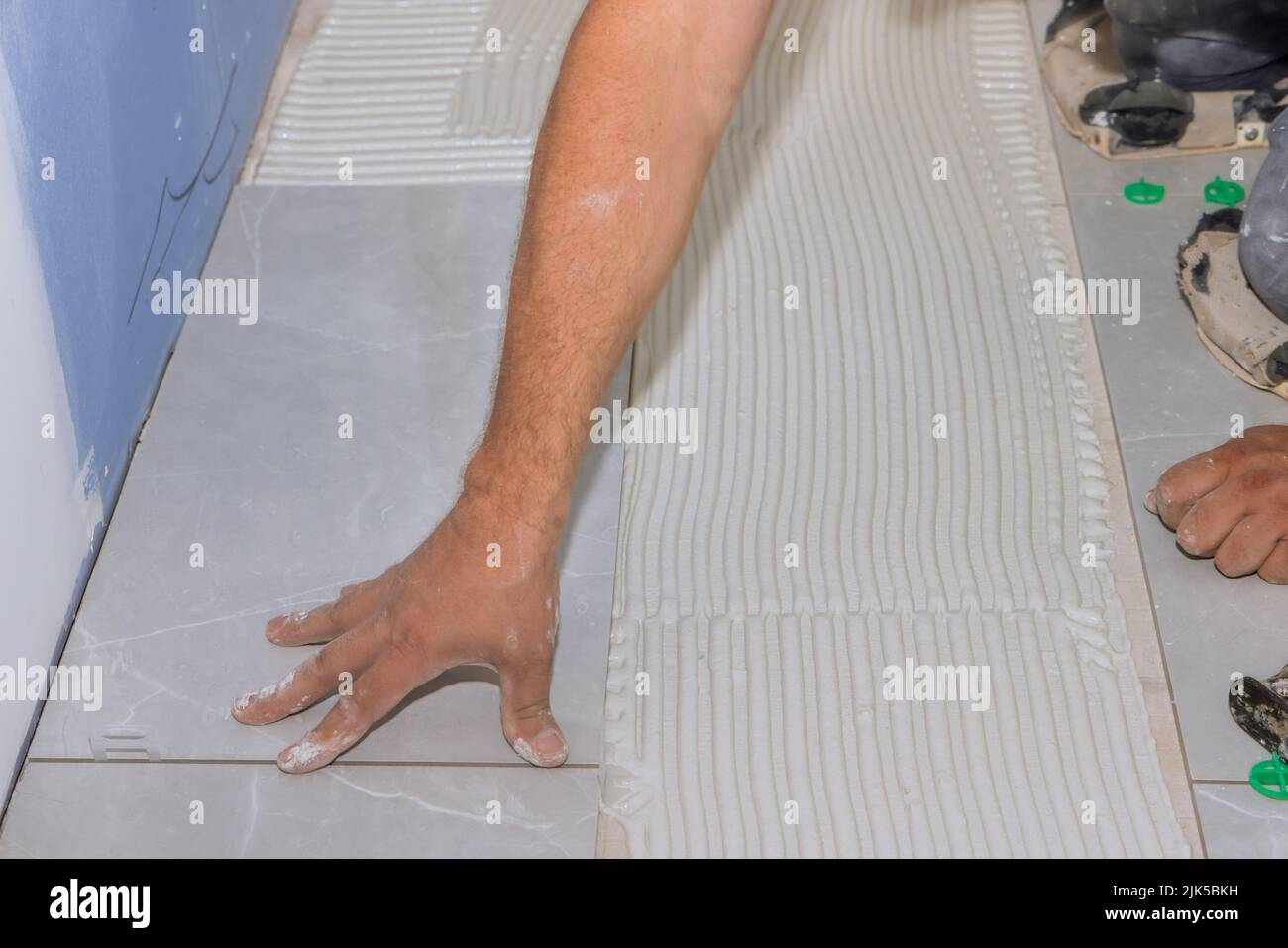 Home improvement construction worker tiling lay ceramic tile floor