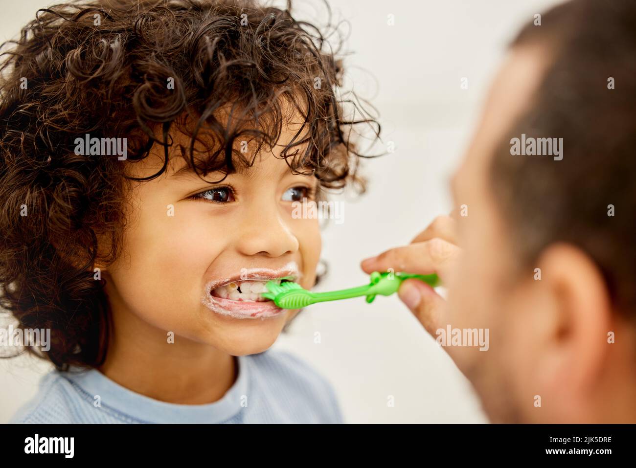 Be true to your teeth and they wont be false to you. a father teaching his son how to brush